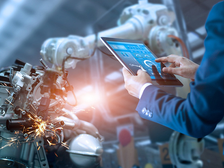 A man with suite examine robot in manufacture industry