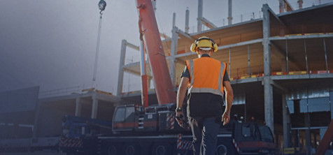 A man wearing construction suit and moving forward to construction site.