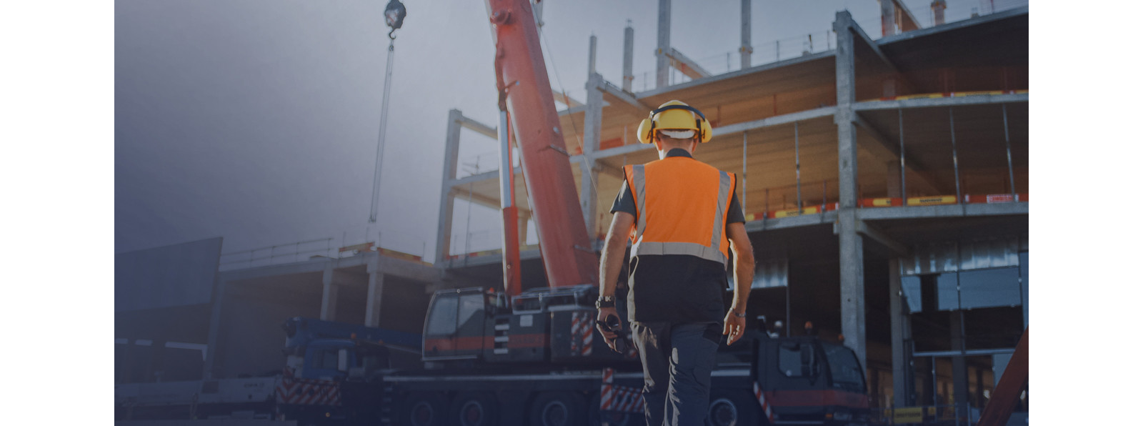 A man wearing construction suit and moving forward to construction site.