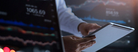 Computer screen and hands holding a tablet