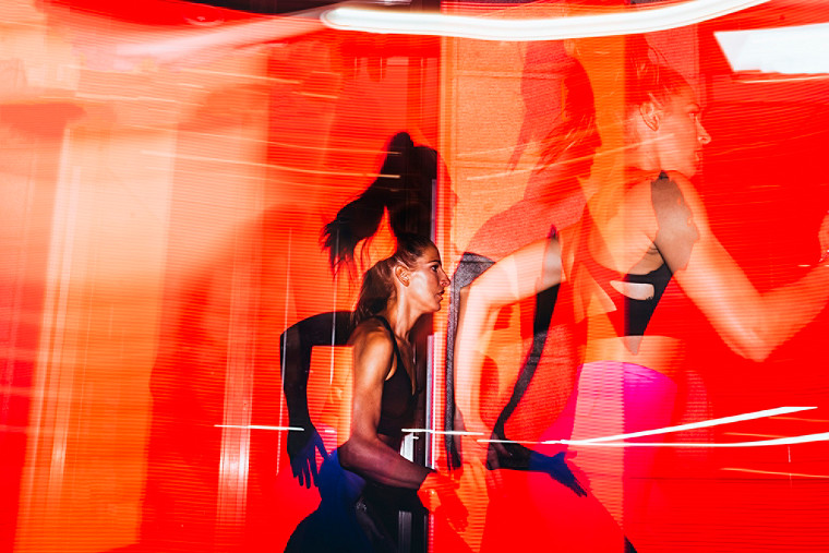 Multiple exposure image of an athelete running against an orange background