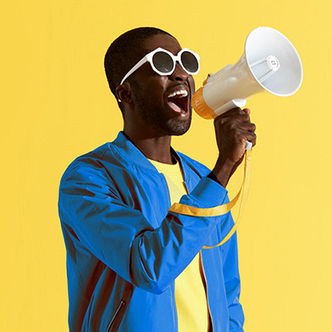 A man on a peppy outfit announcing something holding a megaphone