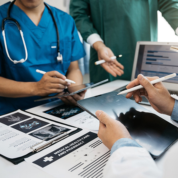 Medical staff working together on multiple devices