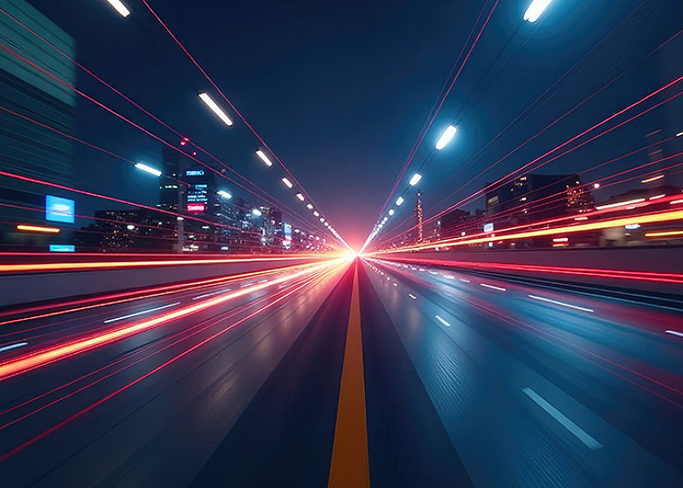 A streak of vehicle lights on a road at night