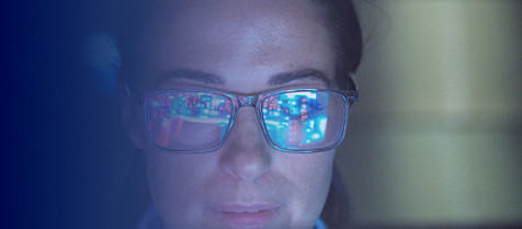 Kvinna som bär glasögon tittar på datorskärmen