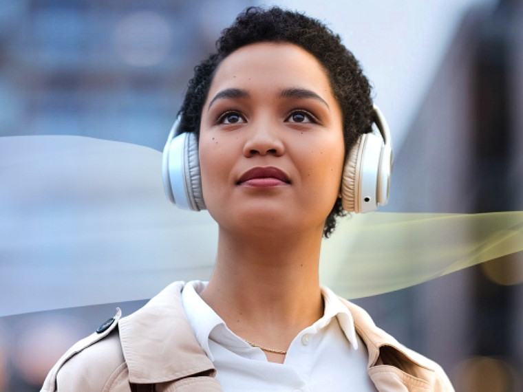 Young person with headphones on looking forward with abstract blue and yellow wave behind them