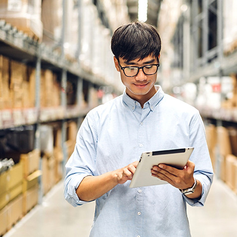 hombre trabajando en un almacén con una tablet