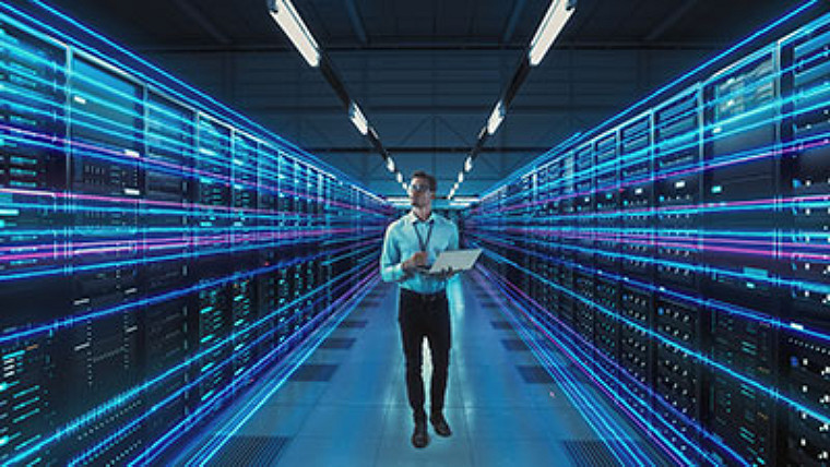 Man standing in the middle of a data center room