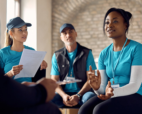 Ein Team von Freiwilligen hört einer Person zu, während sie ihre Idee erklärt