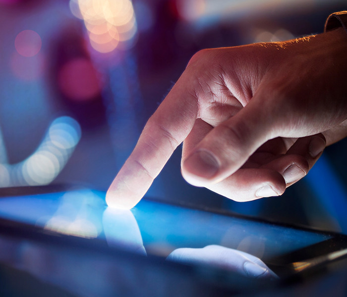 A picture of a finger touching a tablet screen