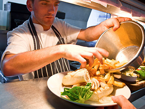 en kock som tar grönsaker på en restaurang