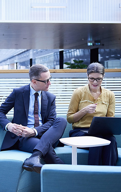 a man and woman in discussion looking at system