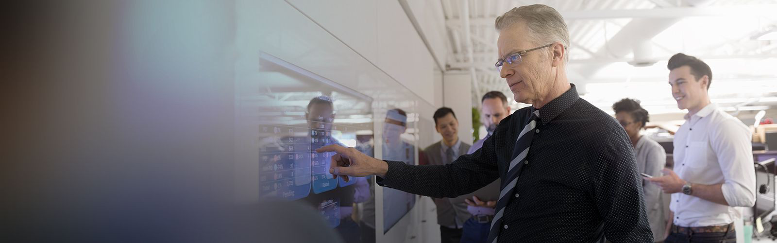 A man using a large touch-screen device for self-service.