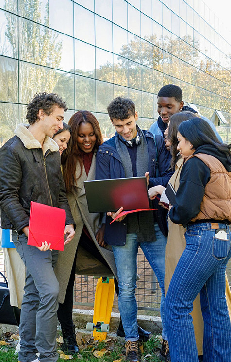 Groupe de jeunes adultes regardant ensemble un ordinateur portable