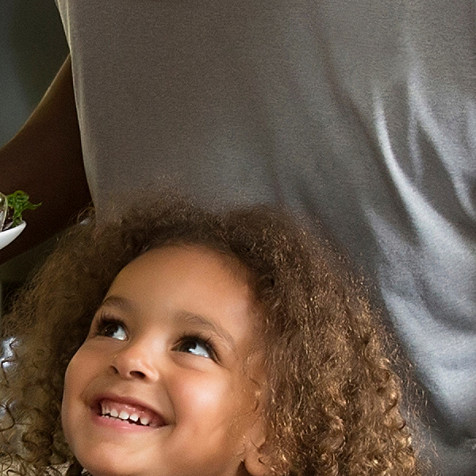 A child looking up to a man with a bright smile.