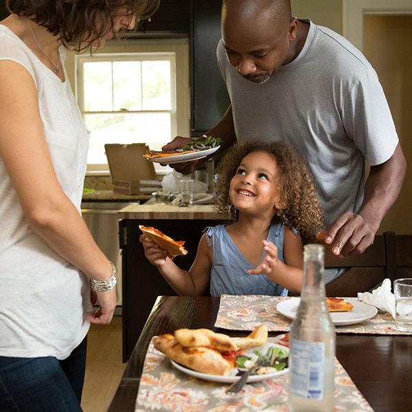 kid interacting with her parents while eating