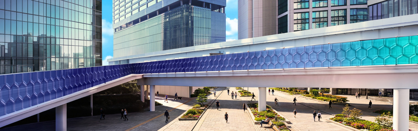 A street view clicked from an overpass, with tall buildings all around it