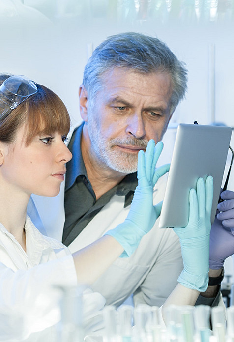 two scientists looking at a tablet