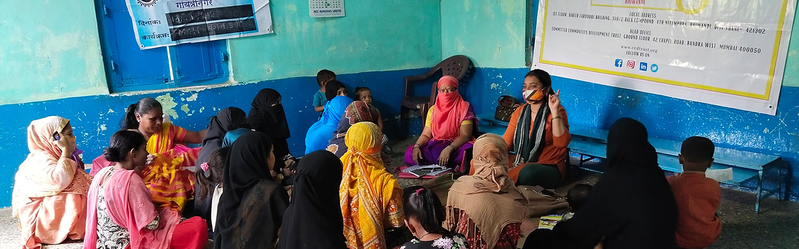 A lady is teaching something to a women sitting Infront of her