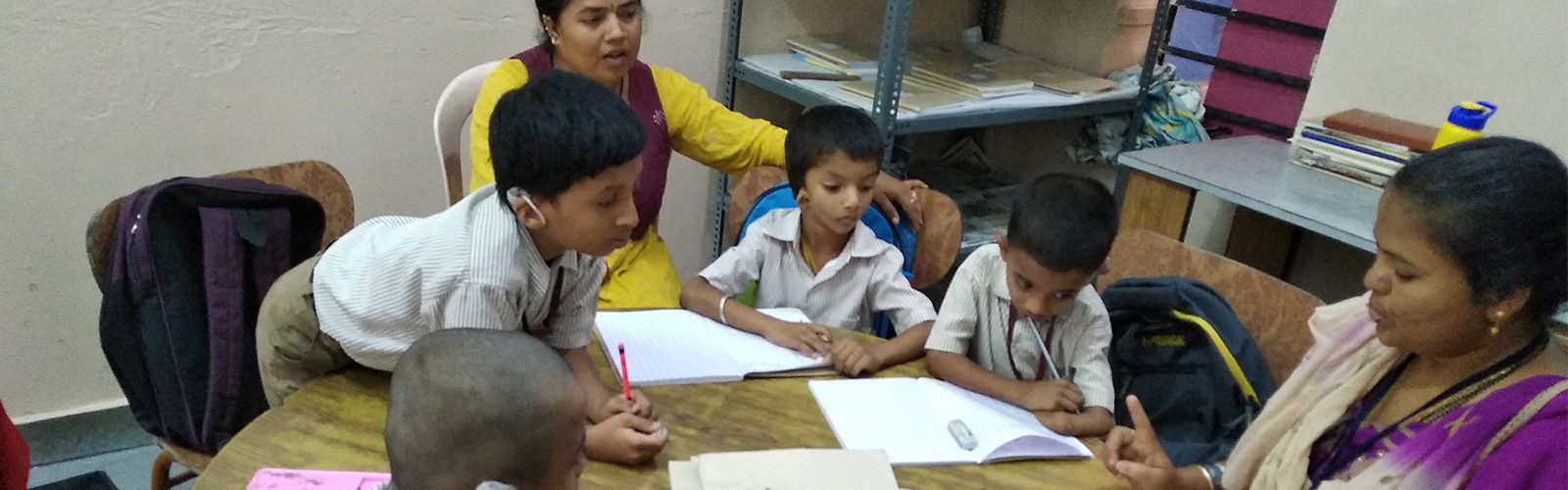 Students are sitting around the teacher and studying