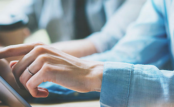 Mains travaillant sur l'écran d'une tablette