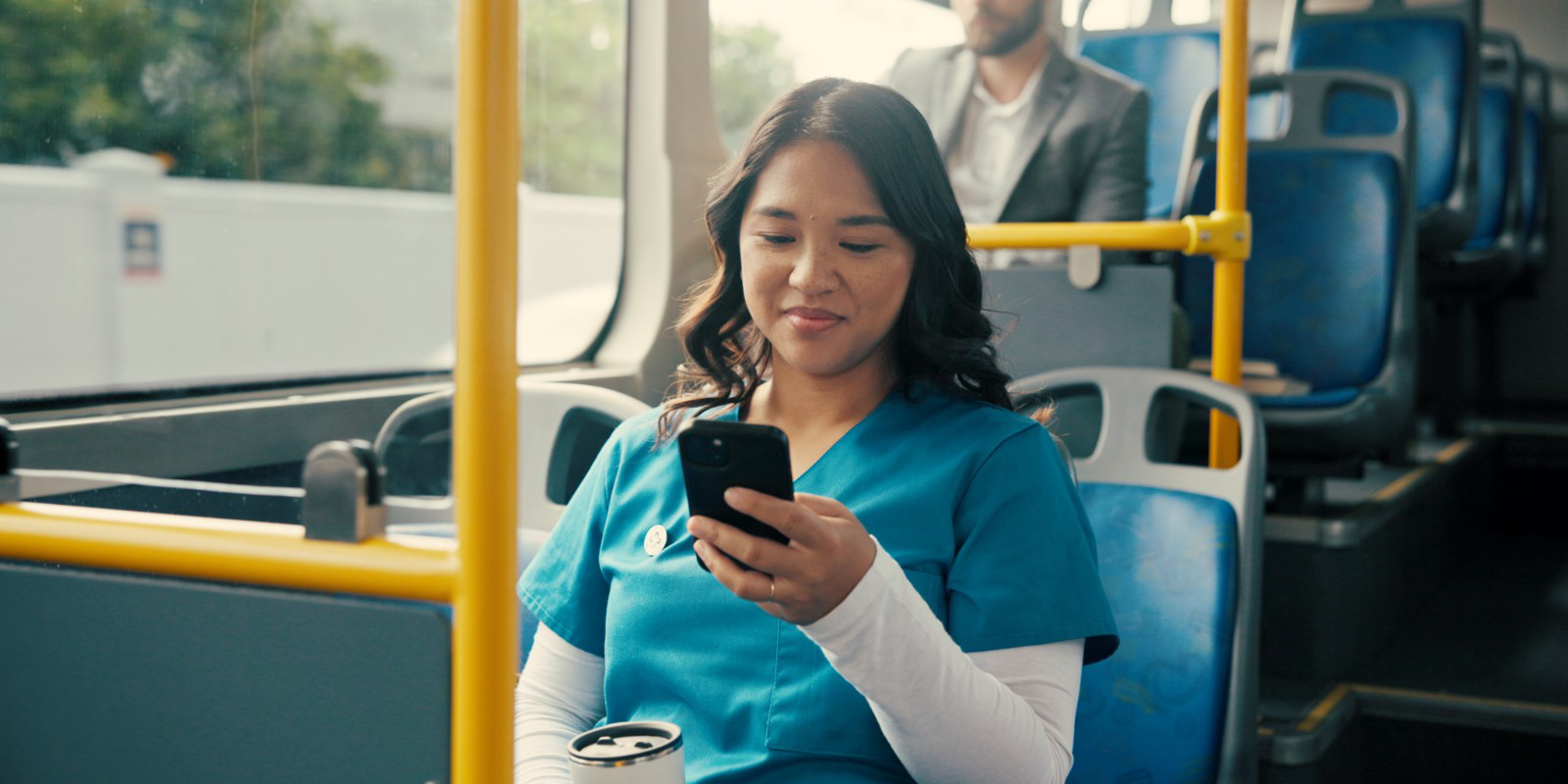 Health worker sitting in public transport using her phone