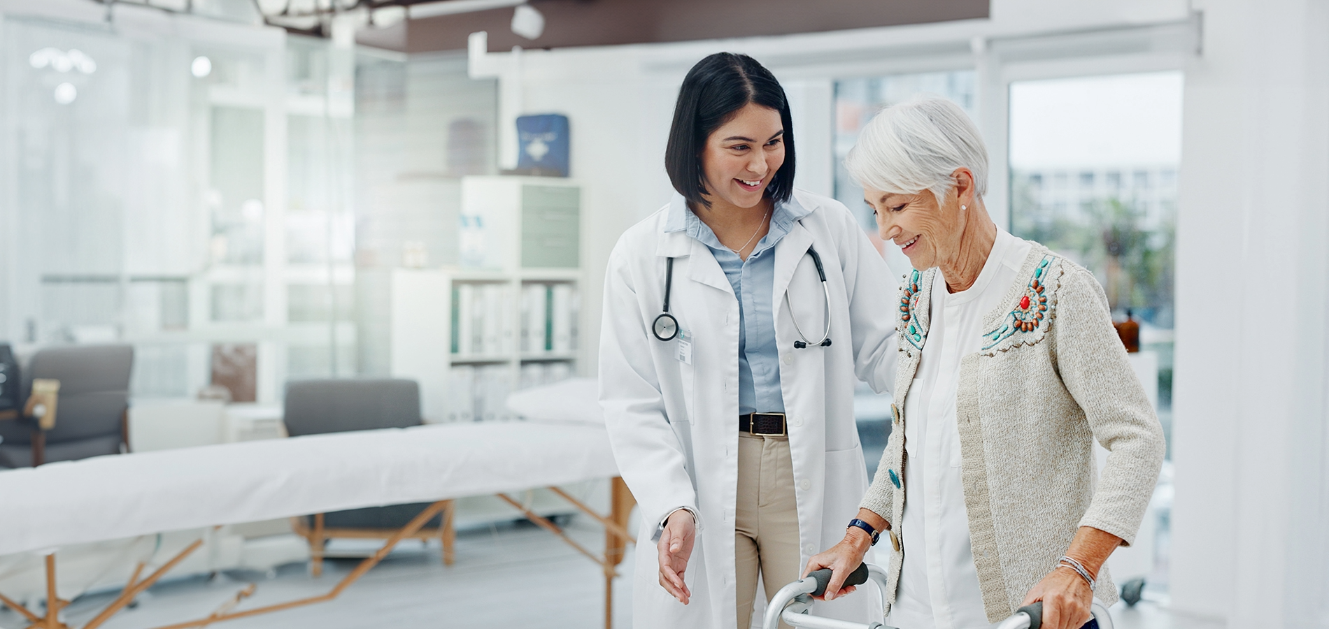 A doctor helping an aged lady to walk