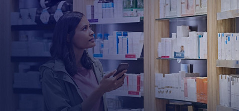 Lady with mobile at the shelves in a store