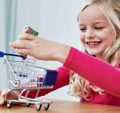 enfant jouant avec un mini chariot d'épicerie