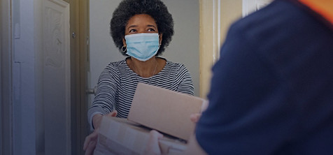 woman wearing mask accepting delivery