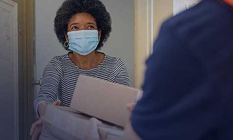 woman wearing mask accepting delivery