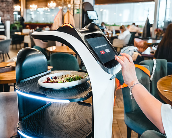 AI-powered robot serving food in a modern restaurant setting.