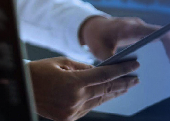 A close-up shot of two hands holding a tablet