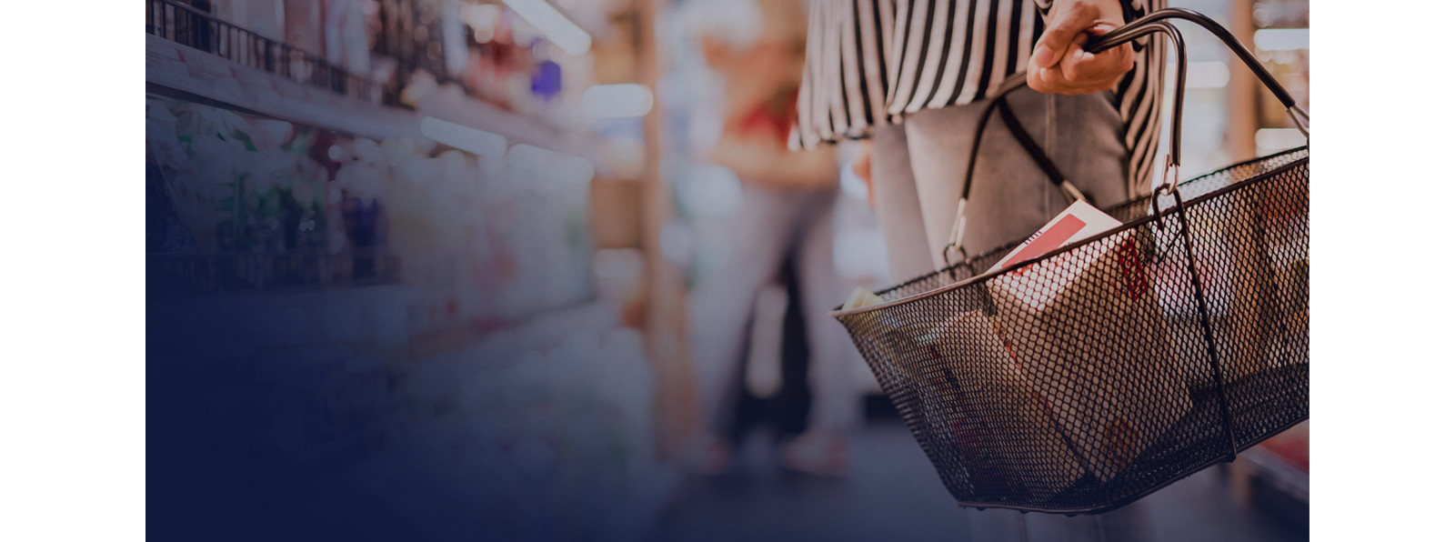 A hand is holding a basket with products inside.