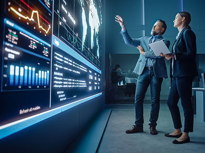 two men in discussion looking at digital display