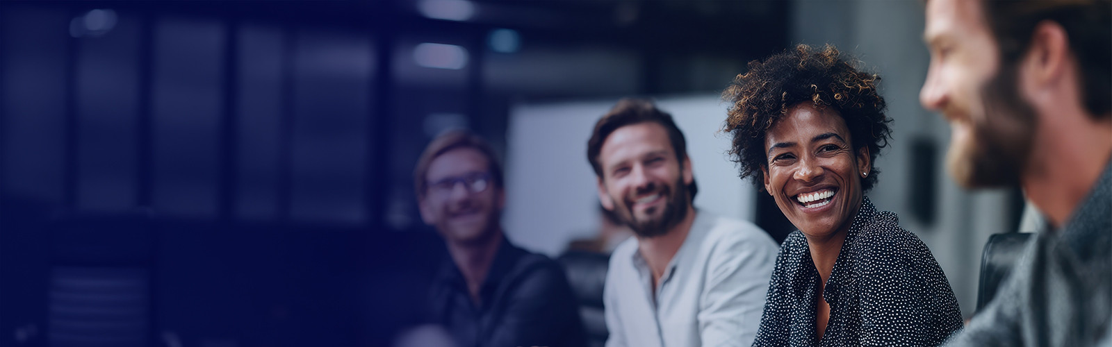 Modern workspace featuring a four-person team seated at a table enjoying their discussion. 