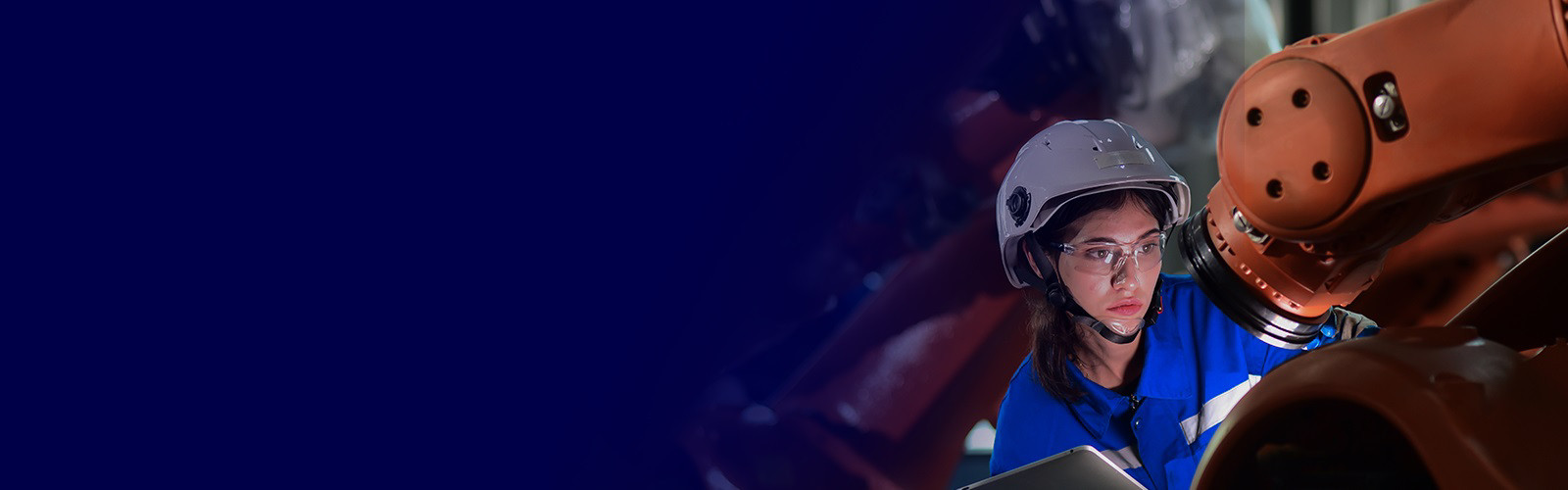 A female factory worker in safety gears operating a machine