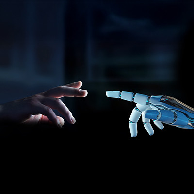 Roboterhand streckt sich in Richtung einer menschlichen Hand und symbolisiert die Verbindung zwischen Technologie und Menschen