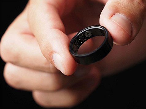 Person hält einen schwarzen Ring mit der Aufschrift „Love“ (Liebe) in der Hand – ein einfaches, aber bedeutungsvolles Schmuckstück