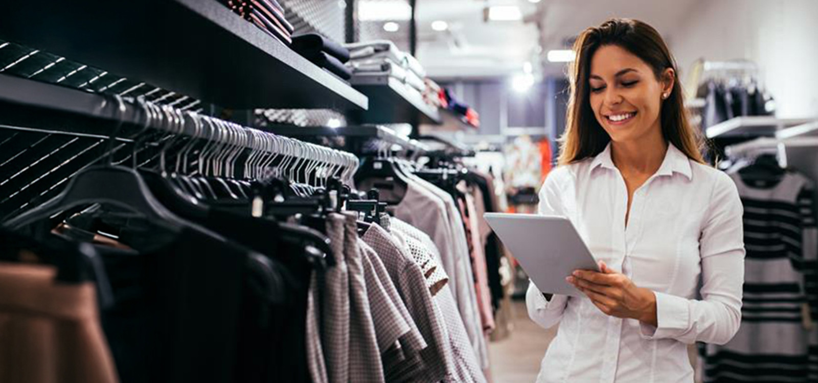 A woman looking into a tablet smiling in a retail store