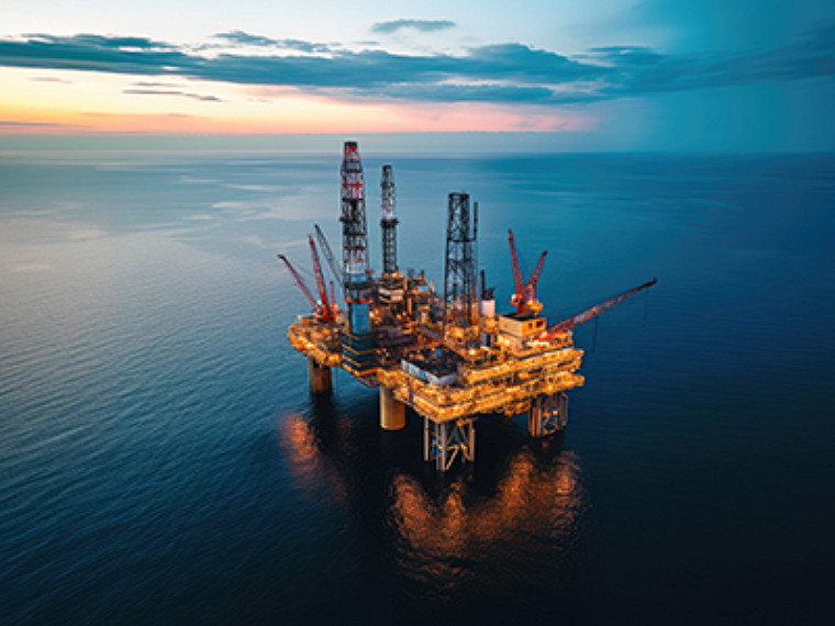 Vista aérea de una plataforma petrolífera en alta mar al atardecer