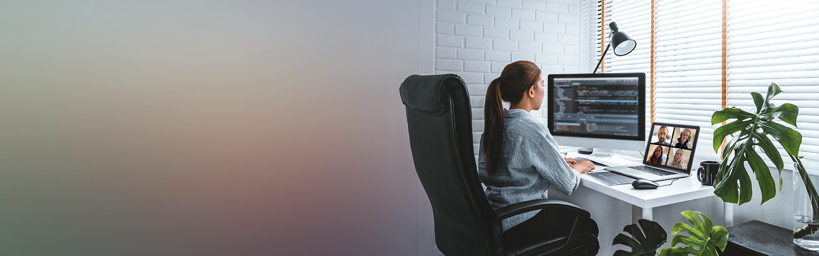 femme assise à un bureau regardant un écran d'ordinateur