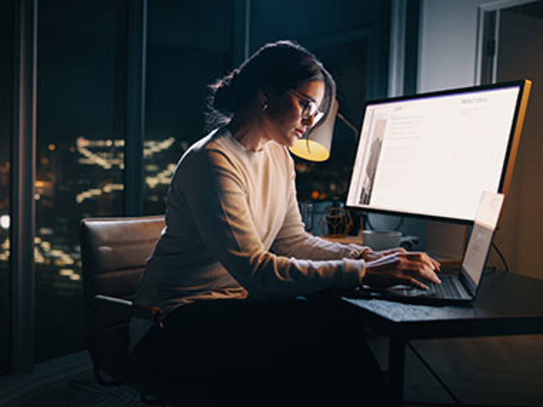 Eine Frau arbeitet spät abends an ihrem Computer