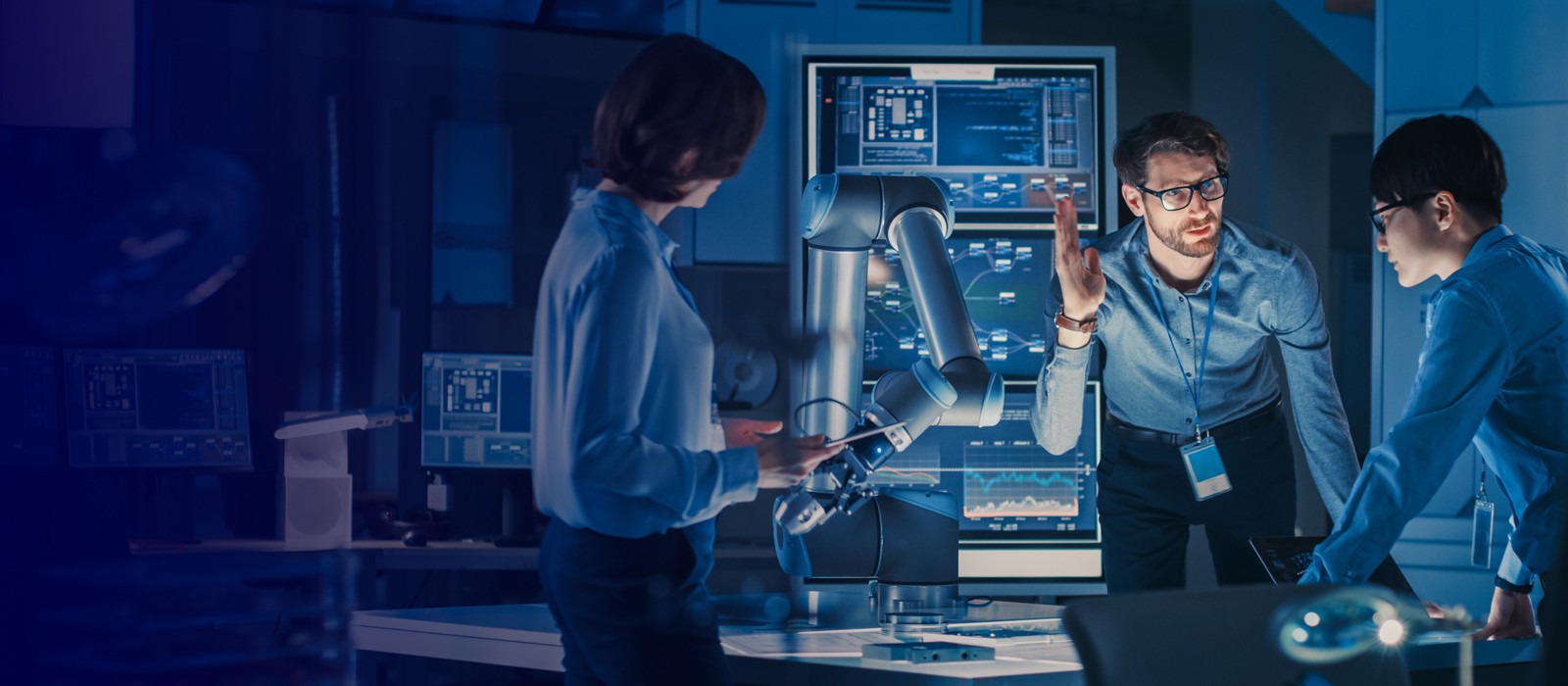 Three coworkers discussing in a robotic laboratory