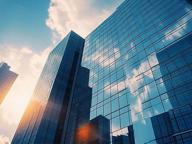 A view of tall buildings with sunlight streaming through, creating a bright and vibrant urban scene.