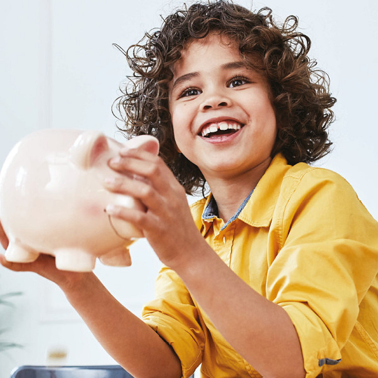 enfant souriant portant ses économies futures