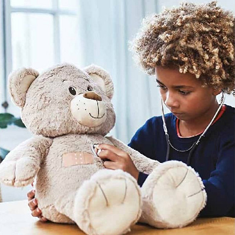 a kid wearing a stethoscope and holding a teddy bear