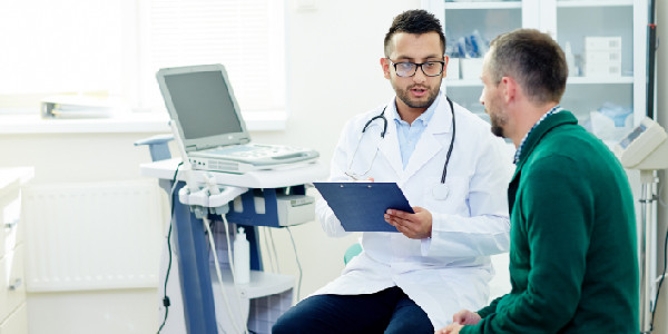 a doctor holding a notepad discussing with a patient