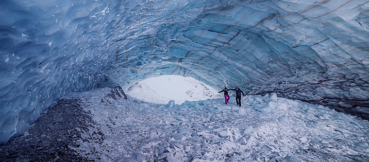 Couple marchant dans une grotte de glace