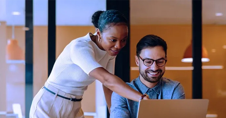 Two colleagues collaborating at a laptop